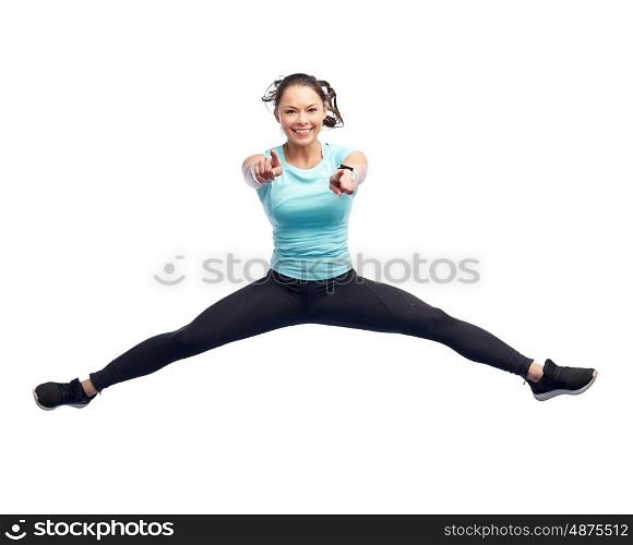 sport, fitness, motion and people concept - happy smiling young woman jumping in air over white background