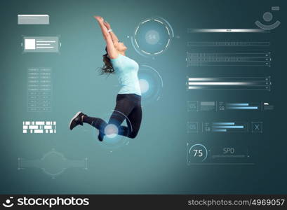 sport, fitness, motion and people concept - happy smiling young woman jumping in air or dancing over blue background. happy smiling sporty young woman jumping in air