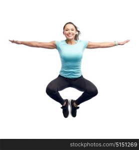 sport, fitness, motion and people concept - happy smiling young woman jumping in air over white background. happy smiling sporty young woman jumping in air