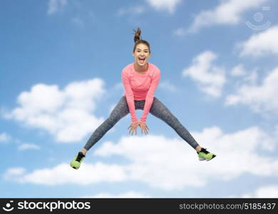 sport, fitness, motion and people concept - happy smiling young woman jumping in air over blue sky and clouds background. happy smiling sporty young woman jumping in sky