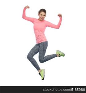 sport, fitness, motion and people concept - happy smiling young woman jumping in air and showing power gesture over white background. happy smiling sporty young woman jumping in air