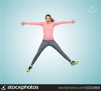 sport, fitness, motion and people concept - happy smiling young woman jumping in air over white background. happy smiling sporty young woman jumping in air