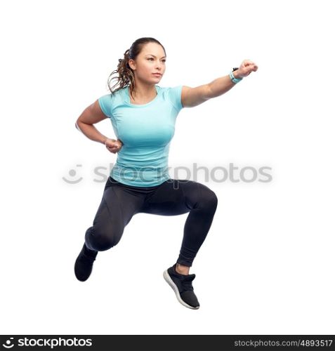 sport, fitness, motion and people concept - happy young woman jumping in air in fighting pose over white background