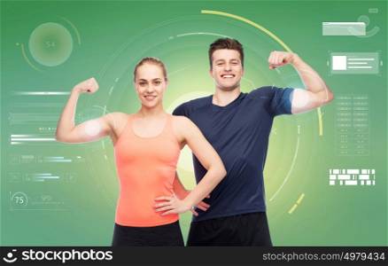 sport, fitness, power, technology and people concept - happy sportive man and woman showing biceps over green background. happy sportive man and woman showing biceps power