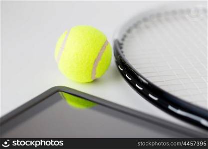 sport, fitness, sports equipment and objects concept - close up of tennis racket with ball and tablet pc computer over white background