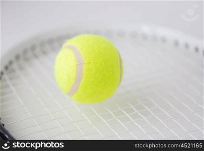 sport, fitness, sports equipment and objects concept - close up of tennis racket with ball