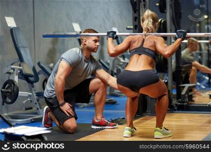 sport, fitness, teamwork, bodybuilding and people concept - young woman and personal trainer with barbell flexing muscles in gym