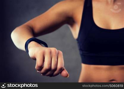 sport, fitness, technology and people concept - close up of young woman with heart-rate watch in gym. woman with heart-rate watch in gym