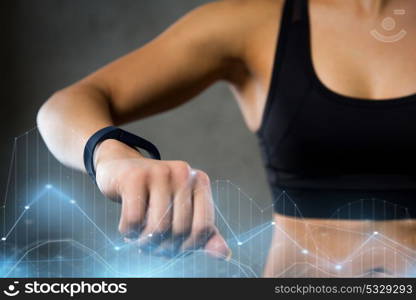 sport, fitness, technology and people concept - close up of young woman with heart-rate watch in gym. woman with heart-rate watch in gym