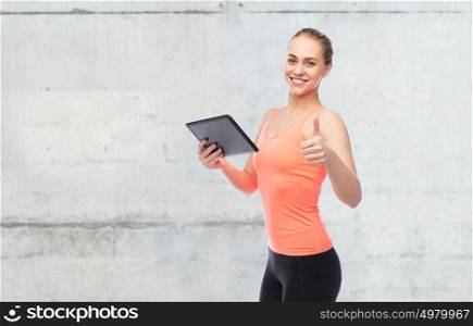 sport, fitness, technology and people concept - happy smiling sportive young woman with tablet pc over concrete wall background. happy smiling sportive young woman with tablet pc