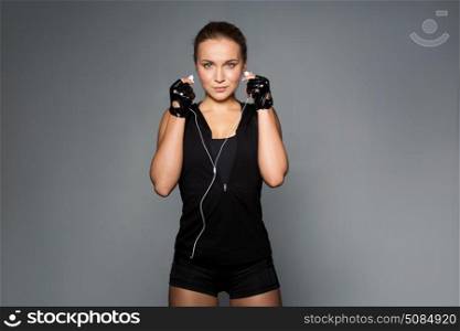 sport, fitness, technology and people concept - young woman with earphones listening to music in gym. woman with earphones listening to music in gym. woman with earphones listening to music in gym