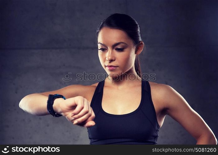 sport, fitness, technology and people concept - young woman with heart-rate watch in gym. young woman with heart-rate watch in gym