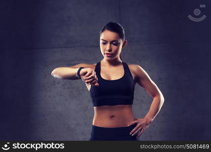 sport, fitness, technology and people concept - young woman with heart-rate watch in gym. young woman with heart-rate watch in gym