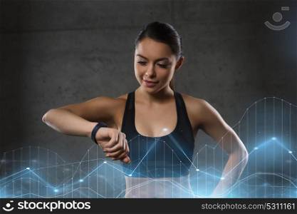 sport, fitness, technology and people concept - young woman with heart-rate watch in gym. young woman with heart-rate watch in gym