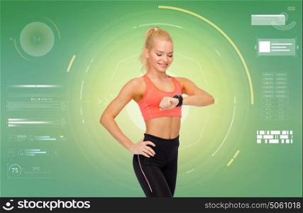sport, fitness, technology, exercising and people concept - smiling woman looking at heart rate tracker or smartwatch on hand over green background. smiling woman with fitness tracker or smartwatch