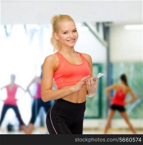 sport, fitness, technology, internet and healthcare concept - smiling sporty woman with smartphone