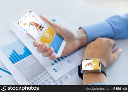 sport, fitness, technology, responsive design and people concept - close up of female hand holding smart phone and wearing watch with sports application on screen