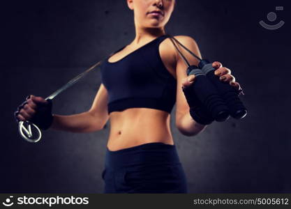 sport, fitness, training, stamina and people concept - close up of young sporty woman with jumping rope. close up of sporty woman with jumping rope