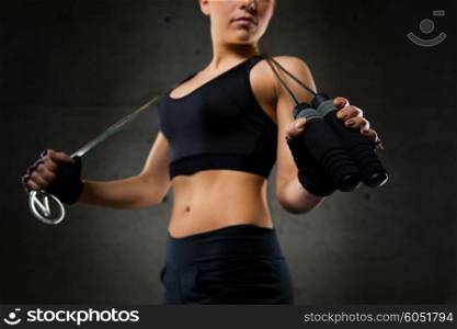 sport, fitness, training, stamina and people concept - close up of young sporty woman with jumping rope