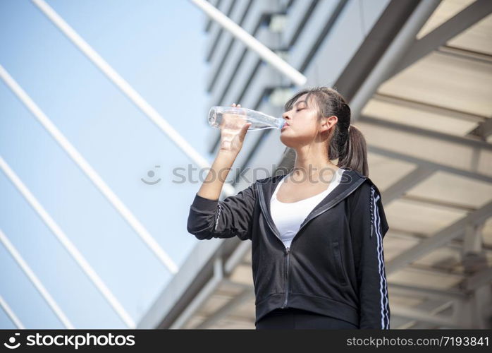 Sport Fitness Women drinking mineral water after running exercise modern city wear wellness sportswear outside. Young woman workout outdoor exercising outside. Healthy wellness lifestyle woman concept