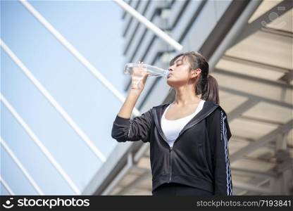 Sport Fitness Women drinking mineral water after running exercise modern city wear wellness sportswear outside. Young woman workout outdoor exercising outside. Healthy wellness lifestyle woman concept
