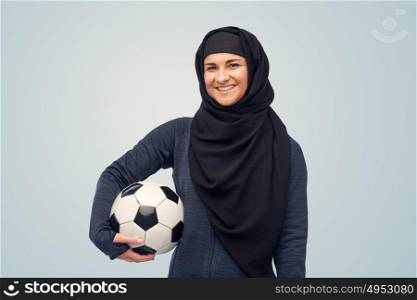 sport, football and people concept - happy muslim woman in hijab with soccer ball over blue background. happy muslim woman in hijab with football