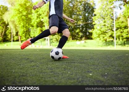 sport, football and people concept - soccer player playing with ball on field. soccer player playing with ball on field