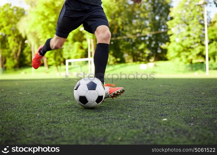 sport, football and people concept - soccer player playing with ball on field. soccer player playing with ball on field