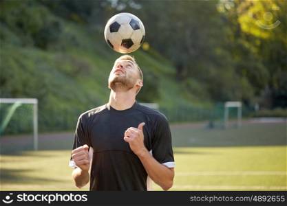 sport, football and people - soccer player playing and juggling ball using header technique on field. soccer player playing with ball on field