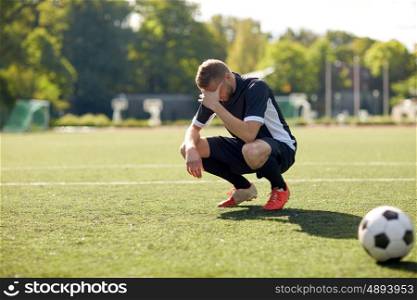 sport, football, fail, loss and people - sad soccer player with ball on field