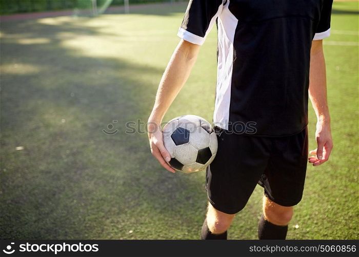 sport, football training and people concept - close up of soccer player with ball on field. soccer player with ball on football field