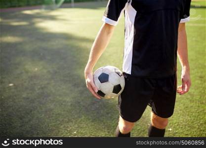 sport, football training and people concept - close up of soccer player with ball on field. soccer player with ball on football field