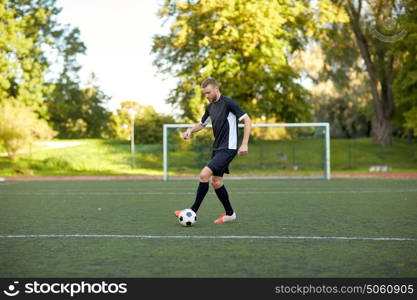 sport, football training and people - soccer player playing with ball on field. soccer player playing with ball on football field