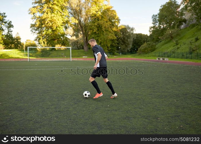 sport, football training and people - soccer player playing with ball on field. soccer player playing with ball on football field