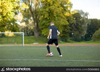 sport, football training and people - soccer player playing with ball on field. soccer player playing with ball on football field. soccer player playing with ball on football field