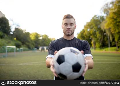 sport, football training and people - soccer player with ball on field