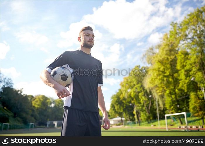 sport, football training and people - soccer player with ball on field. soccer player with ball on football field