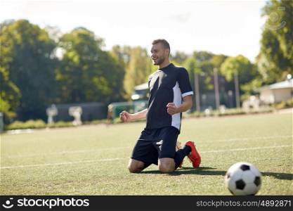 sport, football, win and people - happy soccer player with on field