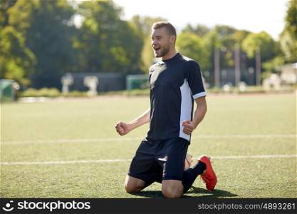 sport, football, win and people - happy soccer player with on field