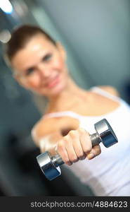 Sport girl. Image of fitness girl in gym exercising with dumbbells