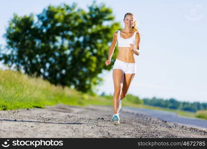 Sport girl. Image of young attractive woman running outdoor