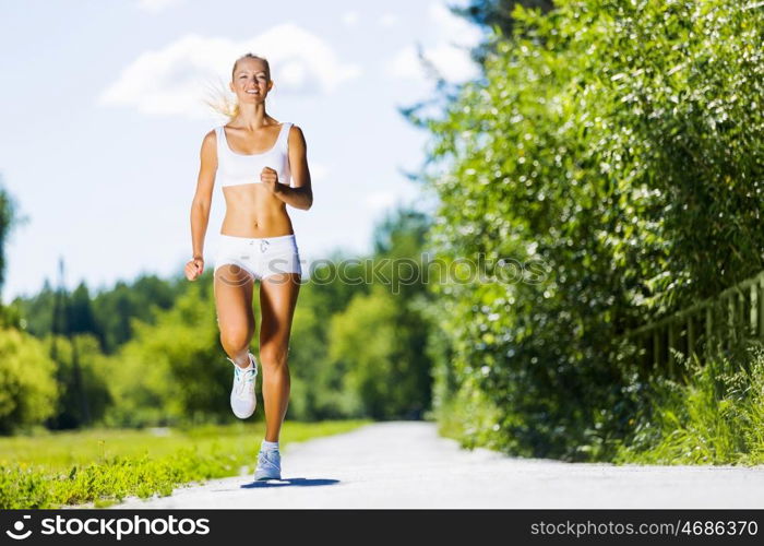 Sport girl. Image of young attractive woman running outdoor