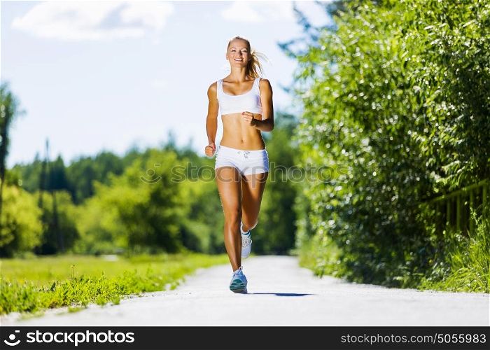 Sport girl. Image of young attractive woman running outdoor
