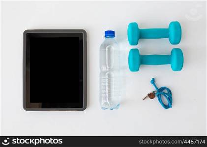 sport, healthy lifestyle and objects concept - tablet pc computer with dumbbells, whistle and water bottle over white background