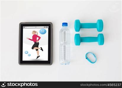 sport, healthy lifestyle, fitness and technology concept - close up of tablet pc computer with dumbbells, fitness tracker and water bottle over white background