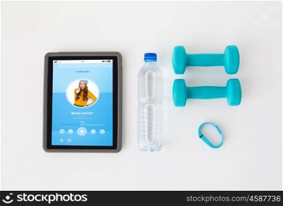 sport, healthy lifestyle, fitness and technology concept - close up of tablet pc computer with dumbbells, fitness tracker and water bottle over white background. tablet pc, dumbbells, fitness tracker and bottle