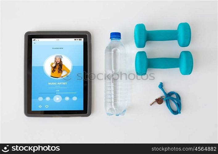sport, healthy lifestyle, fitness and technology concept - tablet pc computer with dumbbells, whistle and water bottle over white background