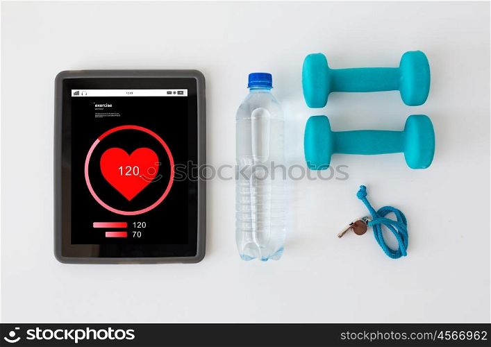 sport, healthy lifestyle, fitness and technology concept - tablet pc computer with heart rate on screen, dumbbells with whistle and water bottle over white background