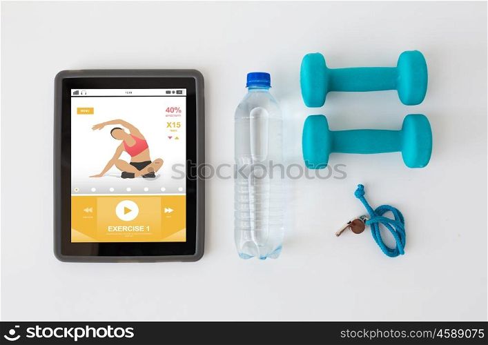 sport, healthy lifestyle, fitness and technology concept - tablet pc computer with dumbbells, whistle and water bottle over white background