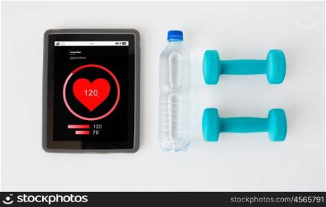 sport, healthy lifestyle, fitness, technology and objects concept - close up of tablet pc computer with heart rate on screen with dumbbells and water bottle over white background